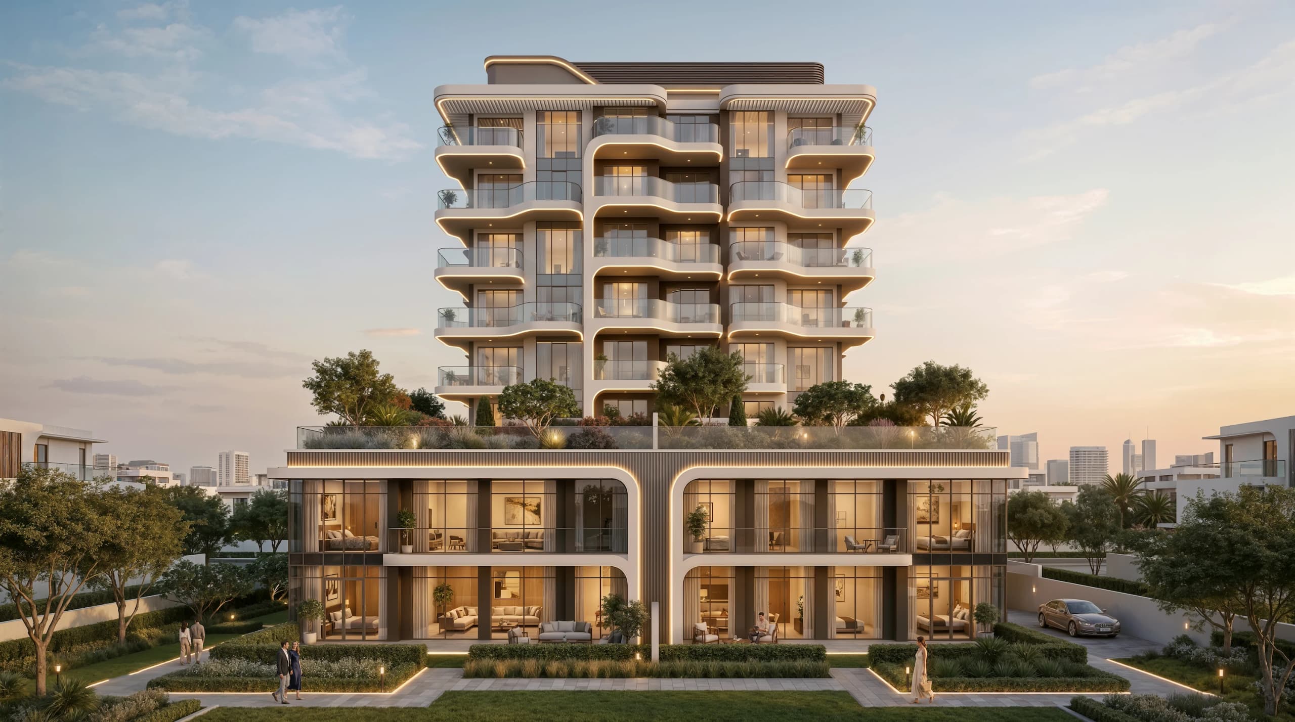 Garden-side view of the tower with landscaped terraces above a lit podium of apartments